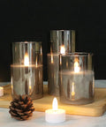 Gray Glass Flameless LED Candles Battery Powered With Timer And 10 Key Remote Real Wax Warm Flicker Set Of 3 on wood tray.