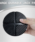 TONDA floor jack rubber pad, round black rubber disk with diagonal grooves, held in hand.