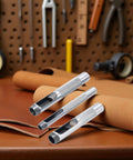Three-Piece Grommet Hole Punch Set For Leatherworking on leather surface with tools in background