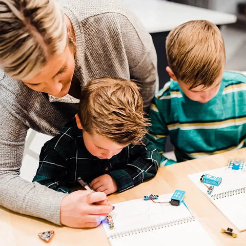 Children using Conductive Ink Pen For DIY Circuits With Silver Ink, Non-Toxic And Easy To Use, writes on any surface from paper to plastic.