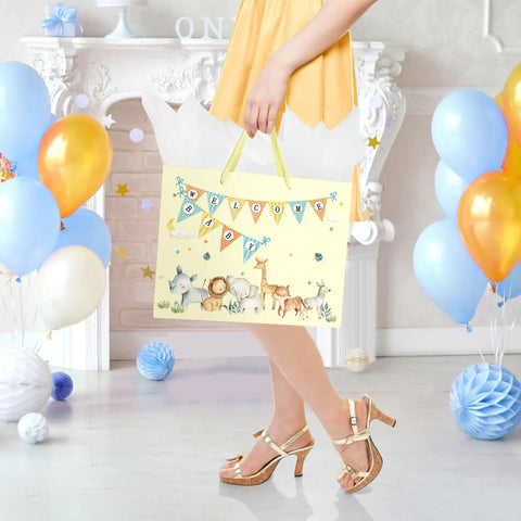 Woman holding 13 inch large baby gift bag for baby shower with tissue paper and greeting card yellow dinosaur design