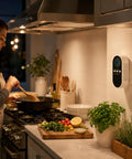 5-In-1 Air Monitor Plug-In With LED Display And Real-Time Gas Detection, mounted on kitchen wall during cooking