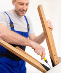 Man using a screwdriver on wooden furniture legs, demonstrating Heavy Duty Carbon Steel Threaded Wood Insert Kit 151 Piece M6 M8 M10.