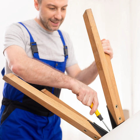 Man using a screwdriver on wooden furniture legs, demonstrating Heavy Duty Carbon Steel Threaded Wood Insert Kit 151 Piece M6 M8 M10.