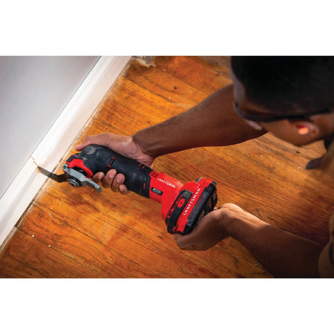 Person using Cordless Oscillating Tool Kit With Blades, Sandpaper, Battery And Charger Included for precise cutting on wooden floor