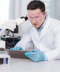 Scientist wearing Anti Fog Safety Goggles For Men And Women With Blue Light Blocking UV Protection Dust Resistant Coating Scratch Resistant Lenses Pink Frame Unisex Eyewear For Work Home Or Travel Clear Vision And All Day Comfort, working in a lab.