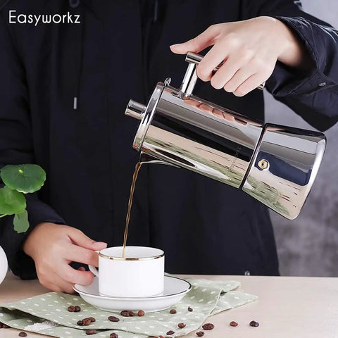 Person pouring coffee from Stainless Steel Stovetop Espresso Maker 6 Cup Moka Pot For Induction into a cup