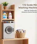 1:12 Scale Mini Drum Washing Machine For Dollhouse Kitchen Setup on wooden shelf with detergent and towels.