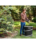 A man using the Badass 40V Cordless Backpack Leaf Blower With Brushless Motor, clearings leaves into a RYOBI collection bag.