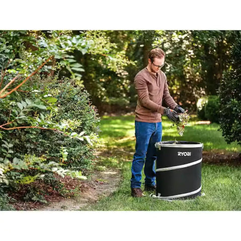 A man using the Badass 40V Cordless Backpack Leaf Blower With Brushless Motor, clearings leaves into a RYOBI collection bag.
