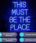 This Must Be The Place Neon Sign Blue Custom Neon Wall Decor on transparent backplate, glowing in dark setting with feature icons