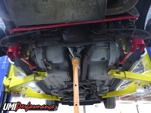 Underbody view of Red Non Adjustable Panhard Bar For 1998 To 2002 Camaro Firebird GM F Body Rear Tubular Suspension Upgrade For Improved Stance Handling And Wheel Alignment installed on rear suspension