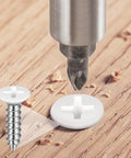 Close-up of a white head wood screw being drilled into wood, part of White Head Wood Screws Set 150 Pieces Size Six In Six Lengths.
