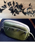 40 Pair Kickass Black Cone Spikes Punk Rivets Hardware Kit With Matching Screws and Heavy Duty Metal Bullet Studs on a green purse.