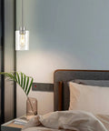 Top Shelf Modern Farmhouse Brushed Nickel Pendant Lights With Clear Glass Shades And Adjustable Rods above a bedside with plant decor.