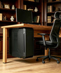 Hella Sturdy Under Desk Computer Mount Gonna Lock Your Main Rig Tight Fits Most Mid Size Cases Saves Desk Space Easy Screwless Clamp Stand supports a black PC case under a wooden desk.