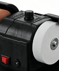 Close-up of Badass Compact Table Grinder Featuring Dual Polish Discs for Quick Blade Sharpening, showing dual wheels and power switch.