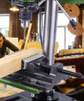 Heavy Duty 4 Inch Drill Press Vise With Soft Jaws For Scratch-Free Clamping holding a wooden plank in a workshop setting.