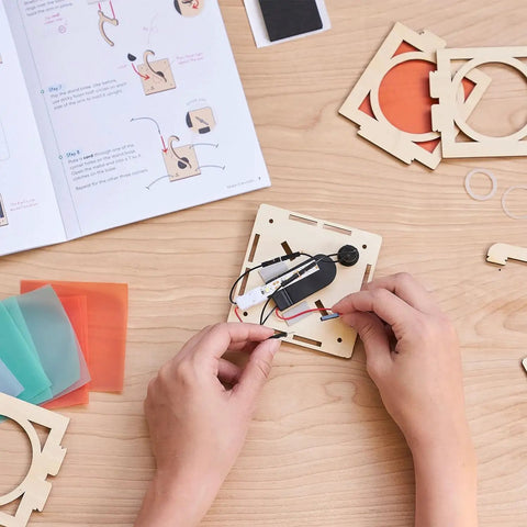 Hands attaching wire to the base of the Levitating Lantern STEM Kit For Kids 9 Plus, A Gravity Defying Physics Project And Robotics Gift