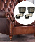 Image of a leather armchair highlighting Two Pack Vintage Zinc Alloy Swivel Caster Wheels With Antique Green Bronze Finish for furniture.
