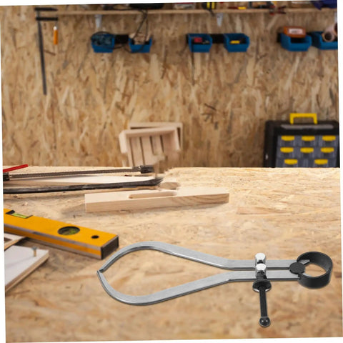 The Real Deal Heavy Duty Outside Caliper For Woodturning Precision Measuring Tool Built Tough Using Premium Carbon Steel, placed on a wooden workbench.