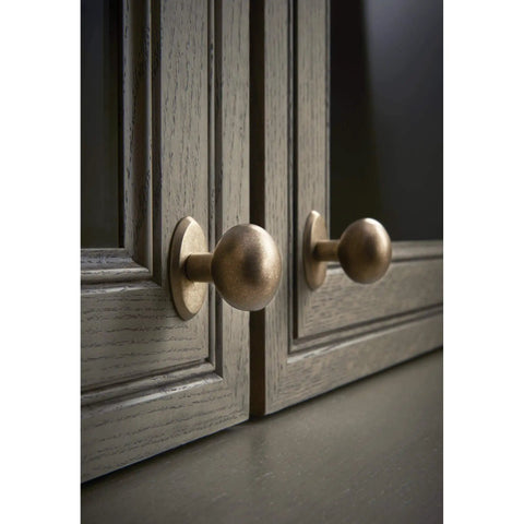 Aspen Round Cabinet Knob In Light Bronze Finish, One And One Eighth Inch Diameter, Seven Eighths Inch Projection on gray cabinets