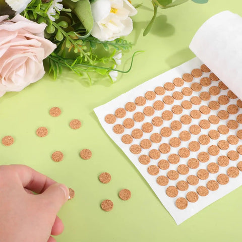 Killer Grip Peel And Stick Cork Bumper Pads For Kitchen Cabinets Furniture Drawers Self Adhesive Dots on a green background.