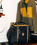 Monster 48L Gear Hauler Tote Bag in recycled nylon, green and yellow accents, for car trunk storage near a fleece jacket