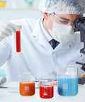Scientist using microscope with Glass Beaker And Graduated Cylinder Kit, borosilicate lab glassware set in science class