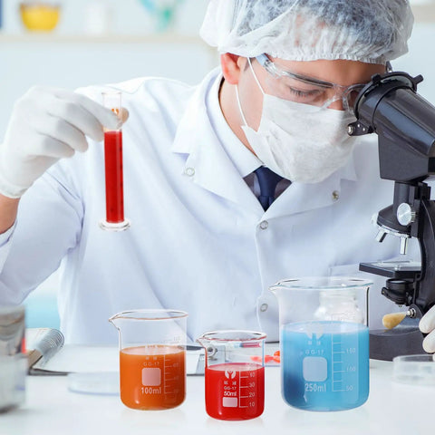 Scientist using microscope with Glass Beaker And Graduated Cylinder Kit, borosilicate lab glassware set in science class