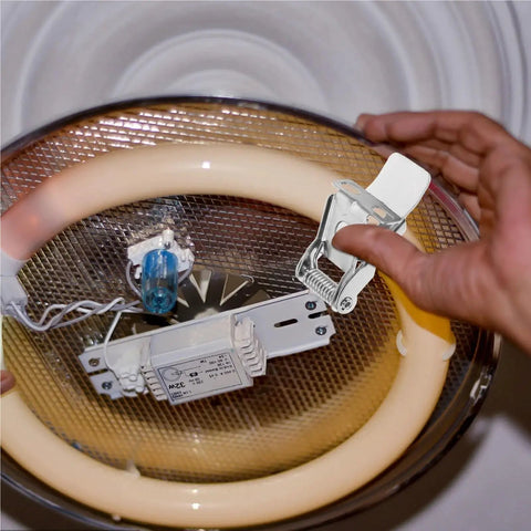 Person installing a 24 Pcs Metal Downlight Spring Clips for Recessed Lighting 3-Hole Brackets on a ceiling fixture.