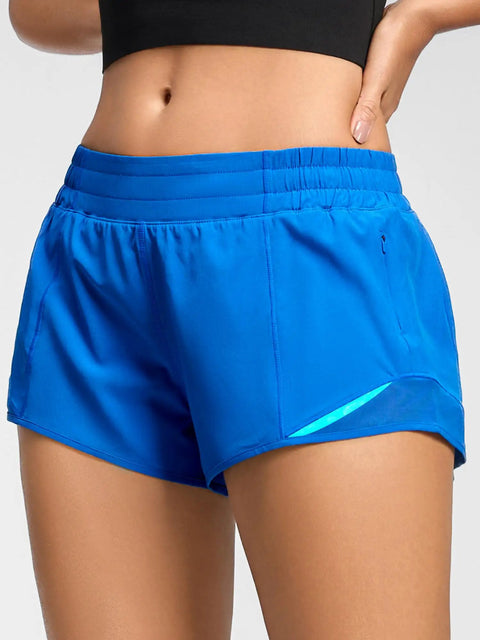 Close-up of Women's Low Rise 2.5 Inch Running Shorts With Built In Liner No Chafe Quick Dry Lightweight Gym Shorts Featuring Breathable Mesh Panels Curved Hems Wide Leg Openings Zip Pocket Blue showcasing the elastic waistband.