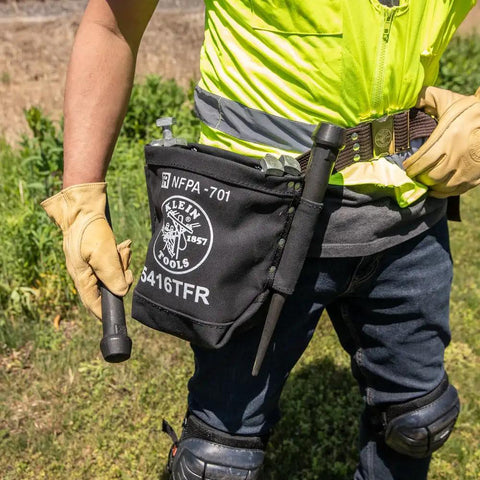 Flame Resistant No 4 Canvas Tool Bag For Bolt Storage With Tunnel Belt Loop And Double Reinforced Bottom Built To Last Rugged Electrician Pouch NFPA 701 Compliant 5 X 10 X 9 Inch Heavy Duty Design shown worn on a worker's belt in the field.