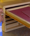 Person using 6-16-TDL Advanced Dry Lube With Teflon 9.3 oz on wooden drawer rails for smooth operation