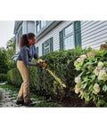User trimming hedge with Badass Cordless Hedge Trimmer Equipped With 60 Volt Lithium Battery For Knockout Yard Cleanup.