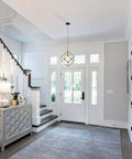 Four Light Black Farmhouse Chandelier With Adjustable Metal Cage in a bright entryway