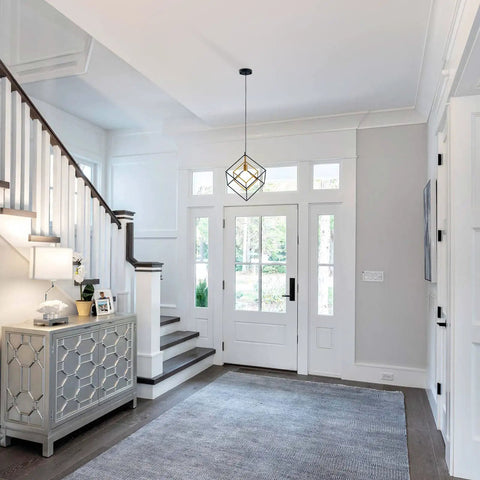 Four Light Black Farmhouse Chandelier With Adjustable Metal Cage in a bright entryway