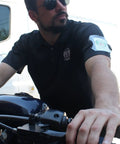 Premium Solid Durable Armband Badge Holder With Hella Secure Stretchy Strap And Easy Hook Loop Fastener For Work Credentials Cards And Passes One Size Fits worn on a man's arm while riding a motorcycle.