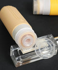 Close-up of beige silicone bottle from On The Go Travel Bottles For Toiletries Set 5 Pack TSA Approved 3oz Leak Proof Refillable Containers.