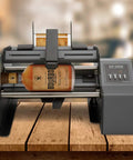 Hustle Ready Semi Automatic Label Applicator For Cylindrical Bottles Cans Jars And Tubes With No Sweat Setup and Smooth Operation Up to 1200 Per Hour For Production Lines, featuring a whiskey bottle.