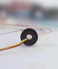 Side view of 7mm Slip Ring Through Hole With 6 Channel 2A Rating, 50 RPM, 220 VAC DC, showing gold contacts and colored wires.