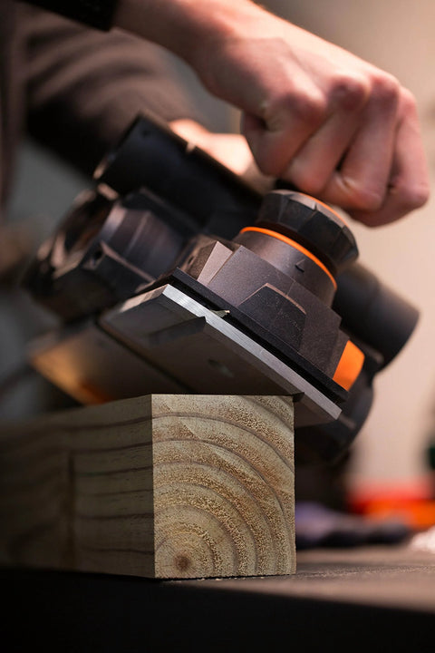 Close-up of a powerful 8-Amp hand planer delivering smooth, precise cuts on wood with a 4-3/8 inch cutterhead, featuring dual dust ports.