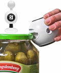 Hand using 8-In-1 Multi-Function Kitchen Opener With Jar Opener on pickle jar, ergonomic non-slip handle, white durable construction.
