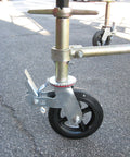 Side view of scaffolding with an installed Set Of Four Eight Inch Caster Wheels With Cast Iron Hubs And Locking Brakes CBM1290 Heavy Duty 1100 Pound Load Capacity One And Three Eighths Inch Stem Fits Two Hole Mounting For Two Inch And Two And A Half Inch Tubes Swivel 360 Degree.