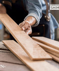 Craftsperson holding Versatile 8 Inch Wood Shims Set For DIY Projects And Home Improvement By Nelson for leveling and spacing.