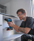 Man using Badass 18V Cordless Drill Driver With Brushless Motor And Smooth Shifting Dual Speed for assembling shelves.