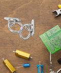 Rock Solid Stainless Steel Pad Eye Plates And Heavy Duty Mounting Rings With M5 Threads on a wooden table with tools.