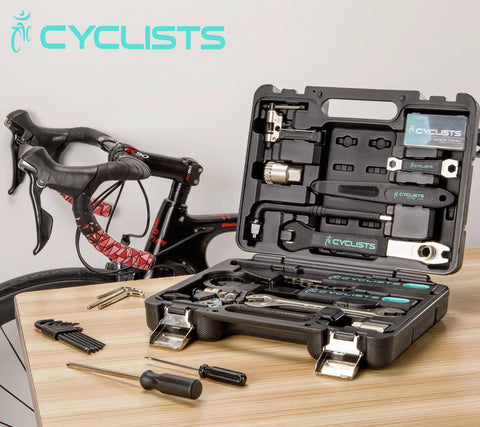 All-In-One Bike Tool Kit With Storage Case, 22-Piece Bicycle Repair Set displayed open on table near road bike.