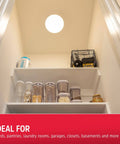 Ceiling view of Cordless LED Ceiling Light With Wireless Remote Control 300 Lumens Of Diffused Bright White Light No Wiring Needed Energy Efficient Fixture For Closets Laundry Rooms Garages Sheds And More installed, illuminating a small pantry space.
