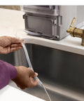 Hand holding water line connected to the Legit Nugget Ice Maker, Portable Countertop Pellet Ice Machine, Stone Grey.